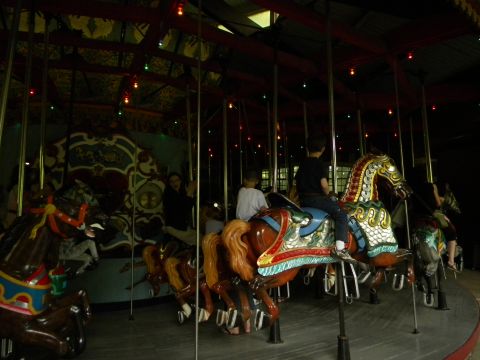 1992 Ford Bronco - A carousel with several horses and riders is illuminated by overhead lights.