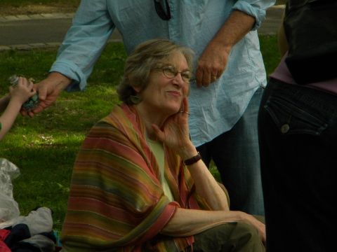 1992 Ford Bronco - A woman wearing glasses and a colorful shawl is seated outdoors, with other individuals visible in the background.