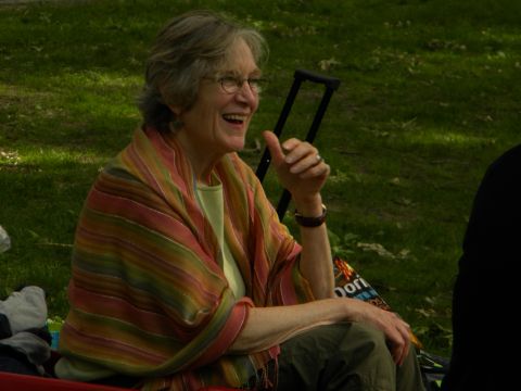 1992 Ford Bronco - A woman wearing glasses and a striped shawl laughs while sitting outside on a grassy area.