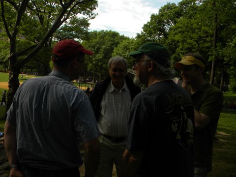 1992 Ford Bronco - A group of men converse in a park setting, with trees and a baseball field visible.