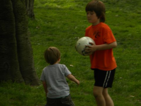 1992 Ford Bronco - Two boys are playing with a soccer ball in a grassy area with a large tree trunk visible.