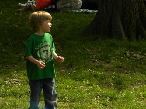 1992 Ford Bronco - A young boy stands in a grassy area, looking to the side.