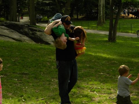 1992 Ford Bronco - A man carries two children through a park on a sunny day, with a watermark visible in the lower right corner.