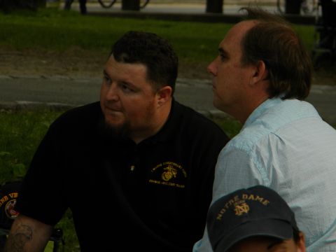 1992 Ford Bronco - Two men engage in conversation outdoors, with one sporting a Marine Corps emblem on his shirt and the other in a light blue collared shirt.