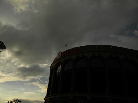 1992 Ford Bronco - Stadium exterior under a dramatic cloudy sky. The name "FIELD" is visible on the building.
