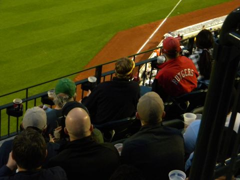 1992 Ford Bronco - Fans watch a game from stadium seats, with one spectator sporting a Rutgers jacket.