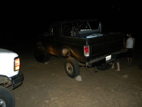 1992 Ford Bronco - Black 1992 Ford Bronco with lifted suspension and off-road tires parked at night.