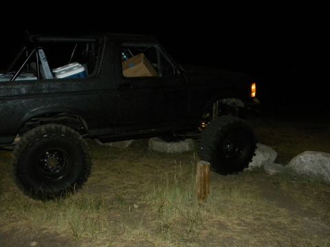 1992 Ford Bronco - A modified 1992 Ford Bronco sits on rocks and grass under the night sky.