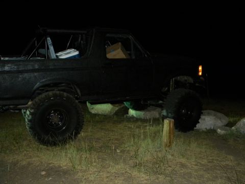 1992 Ford Bronco - This black SUV, modified for off-road use, is seen on rough terrain under the cover of darkness.