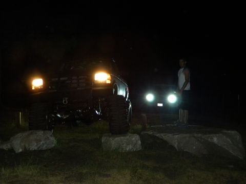 1992 Ford Bronco - A lifted 1992 Ford Bronco is parked on rocks at night, with another vehicle and a person visible in the background.