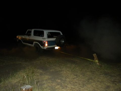 1992 Ford Bronco - A Ford Bronco is being towed at night, kicking up dust and smoke.