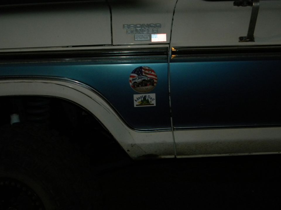 1992 Ford Bronco side view, blue and white two-tone paint, with 'Bronco' badge and stickers