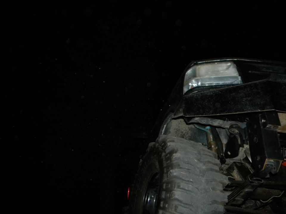 Black 1992 Ford Bronco front tire and fender, low angle view