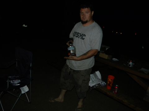 1992 Ford Bronco - A man in a USMC t-shirt stands in the dark holding a bottle of liquor.