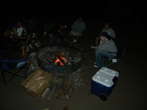1992 Ford Bronco - A group of people are gathered in a dark outdoor setting, with illuminated objects in the center of the scene.