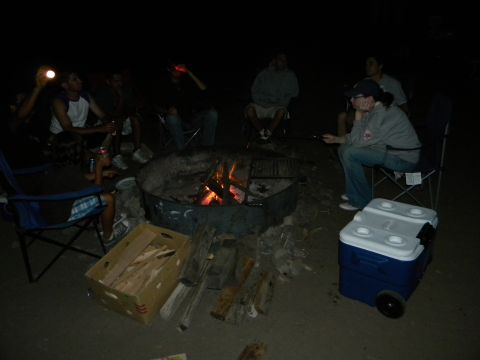 1992 Ford Bronco - Campfire scene with people and a cooler at night.