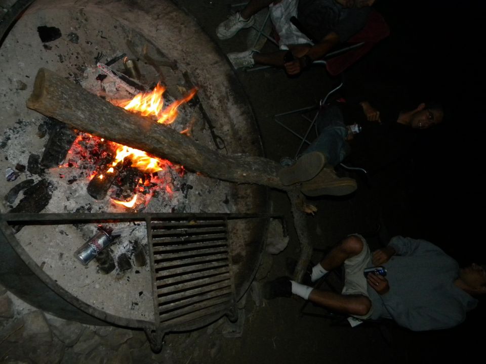 Fire burning in darkness, with debris and glowing embers visible
