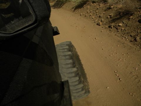 1992 Ford Bronco - Driving on a dusty, unpaved road with sparse vegetation and rocks.