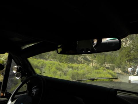 1992 Ford Bronco - View from inside a vehicle, looking out at a dirt road and landscape with another vehicle ahead.