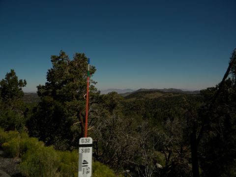 1992 Ford Bronco - A scenic view of rolling hills and trees under a clear blue sky, with a marker post in the foreground.