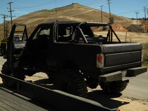 1992 Ford Bronco - This modified 1992 Ford Bronco features a roll cage and lifted suspension, seen from the rear three-quarter angle.