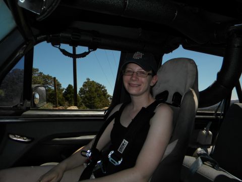 1992 Ford Bronco - A woman is seated inside a modified vehicle, ready for an off-road adventure.