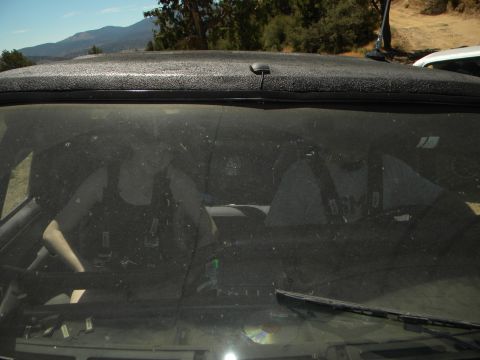 1992 Ford Bronco - Interior of a dusty SUV, seen through the windshield. The dashboard and seats are visible.
