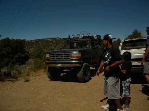 1992 Ford Bronco - A black 1992 Ford Bronco is parked on a dirt road with people nearby.