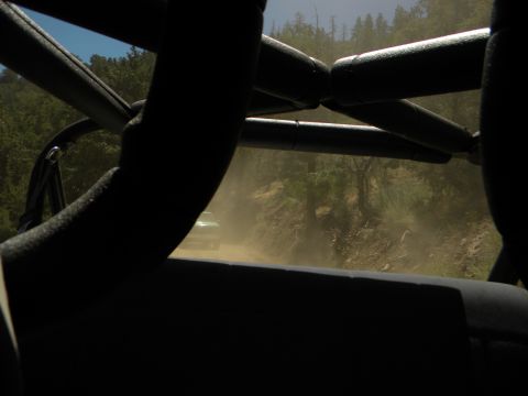 1992 Ford Bronco - Driving on a dusty dirt road, another vehicle is ahead.