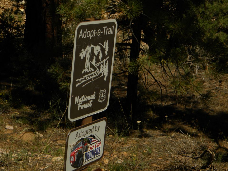 Adopt-a-Trail sign with National Forest logo and a smaller sign saying 'Adopted by So Cal BRONCOS' with a picture of a red Bronco