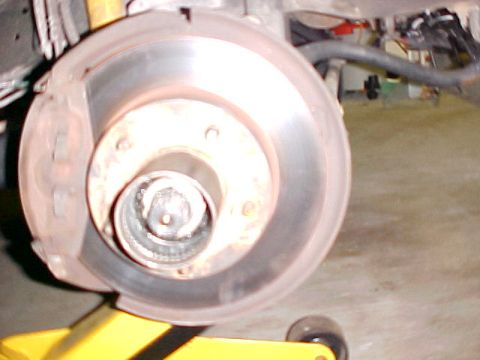 1996 Ford Bronco - The vehicle's brake rotor and hub assembly are visible, supported by a yellow jack.