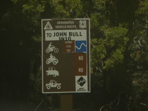 1992 Ford Bronco - A sign indicates a designated vehicle route to John Bull, with icons specifying allowed and disallowed vehicle types.