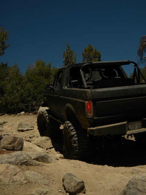 1992 Ford Bronco - This modified Ford Bronco is navigating a challenging rocky terrain under a clear blue sky.
