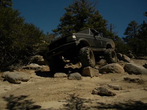 1992 Ford Bronco - This 1992 Ford Bronco is shown off-roading over large rocks on a sunny day.