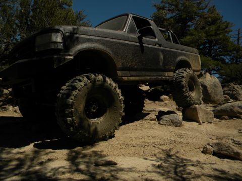 1992 Ford Bronco - This modified Ford Bronco navigates a rocky trail under a clear blue sky.