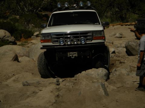 1992 Ford Bronco - A 1992 Ford Bronco tackles a challenging rocky terrain, with another vehicle visible in the background.