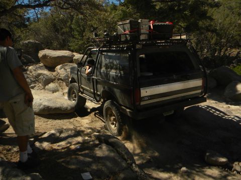 1992 Ford Bronco - Ford Bronco tackling a challenging off-road course on a sunny day.