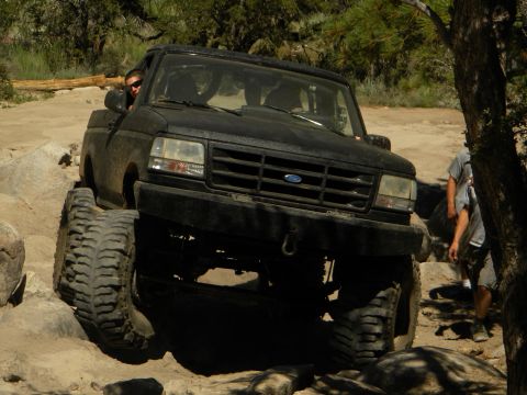 1992 Ford Bronco - This Ford Bronco is navigating a rocky off-road course with a person in the driver's seat.