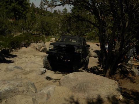 1992 Ford Bronco - A black 1992 Ford Bronco tackles a challenging rocky trail, demonstrating its off-road capabilities.