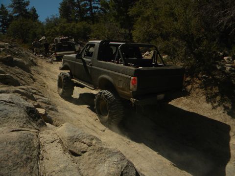 1992 Ford Bronco - A 1992 Ford Bronco navigates a challenging rocky terrain with another vehicle following behind.