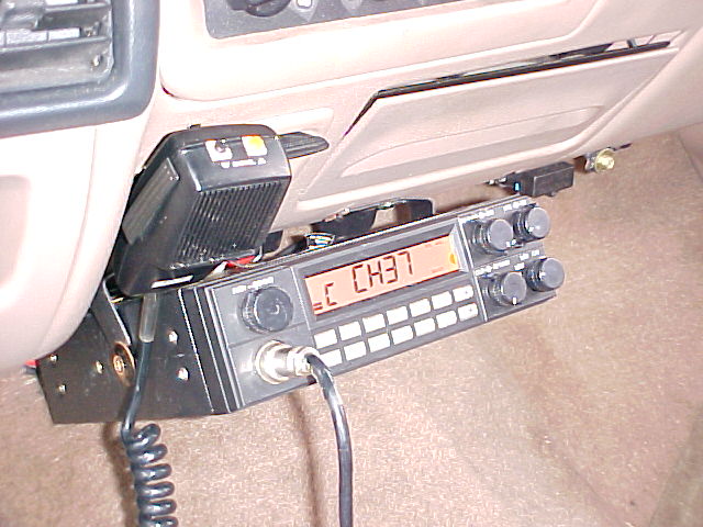 CB radio and microphone mounted on dashboard, showing channel 37