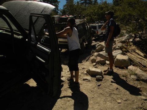 1992 Ford Bronco - Several off-road vehicles are parked on a rocky trail with people standing nearby.