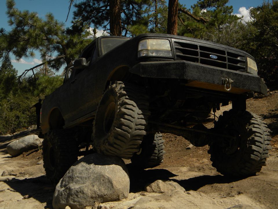 Black Ford Bronco on rocks, front end lifted