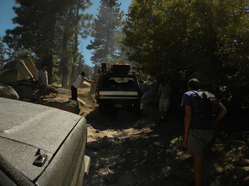 Black 1992 Ford Bronco on a rocky trail with people around