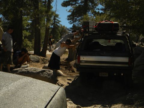 1992 Ford Bronco - People try to push a Ford Bronco out of a tough spot on a rocky, wooded trail.