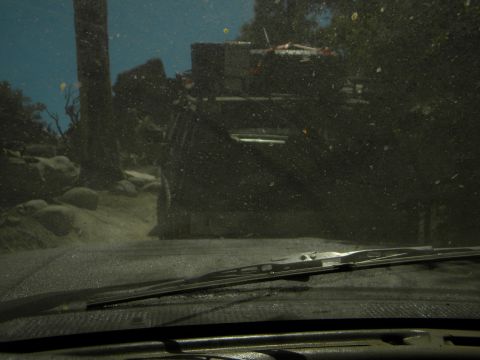 1992 Ford Bronco - A dusty scene shows another vehicle ahead on a rough, outdoor path.