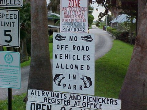 1996 Ford Bronco - A series of signs are posted at the entrance to a park, indicating rules and regulations for visitors.