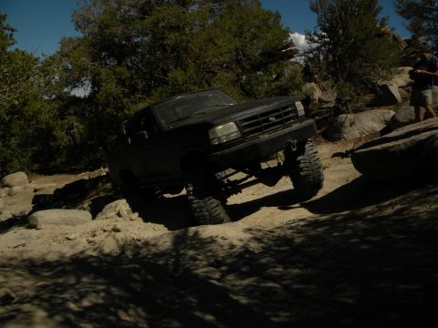 1992 Ford Bronco - A black 1992 Ford Bronco navigates a rocky off-road course.
