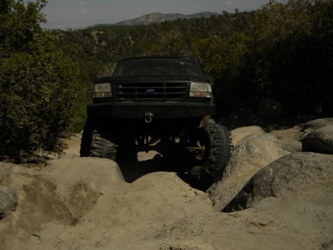 Black SUV with large tires navigating rocky terrain