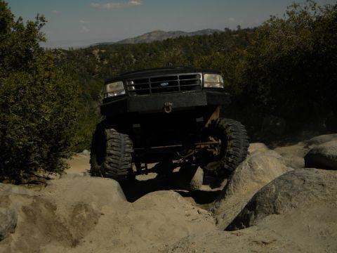 Black 1992 Ford Bronco with custom bumper navigating rocks